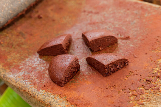 Fresh hand made pieces of chocolate on a stone metate 