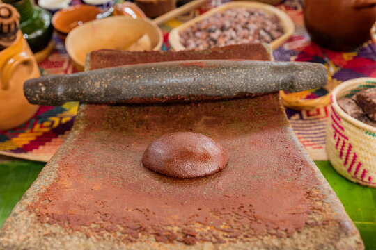 Fresh chocolate sphere on a stone metate with the blurred background