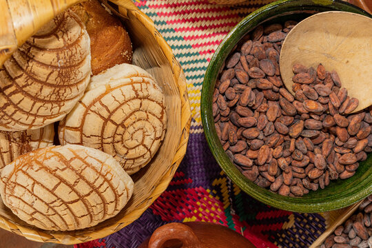 Basket with Mexican bread and a clay bowl filled with cocoa beans