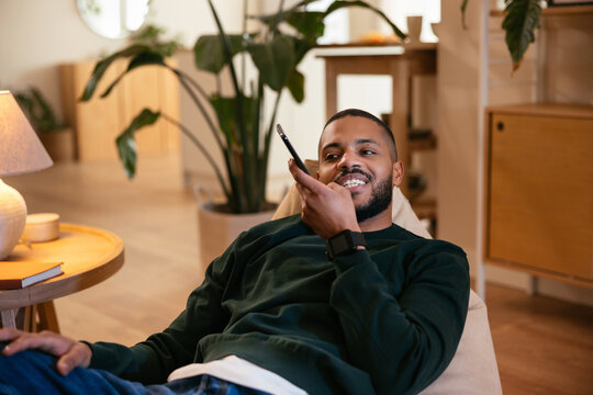 Cheerful black man sending audio message