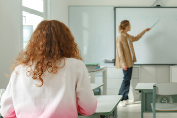 Anonymous girl listening to teacher