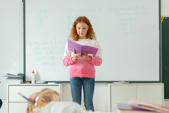 Pupil reading report near whiteboard