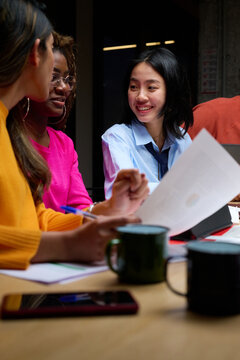 Glad diverse women discussing papers