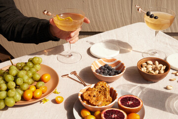 Person holding a cocktail glass among different foods
