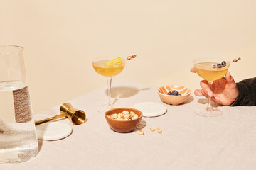 Person holding a cocktail glass among different foods