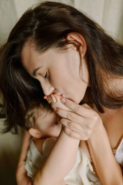 woman kissing baby's heel