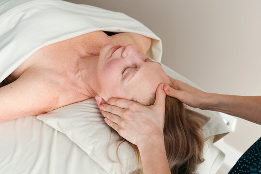 Senior woman having face massage at spa.