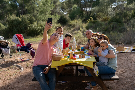 Man Taking Self Shot With Family On Smartphone