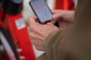 Man scanning qr code of rental bike