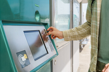 Citizen inserting coins in vending tickets
