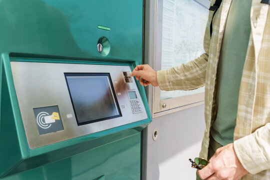 Citizen inserting coins in vending tickets