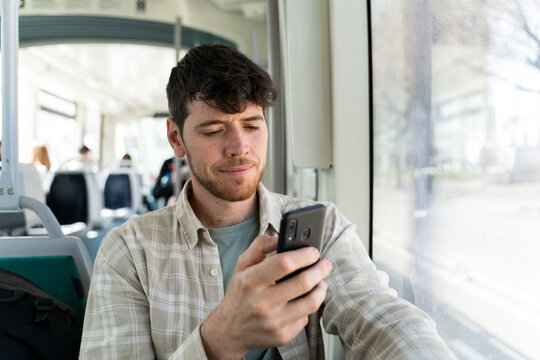 Man using phone traveling by public transport