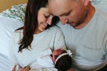 parents look lovingly at newborn baby