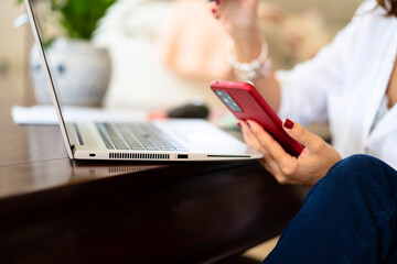 Crop businesswoman using mobile phone