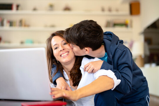 Son kissing working mother on cheek