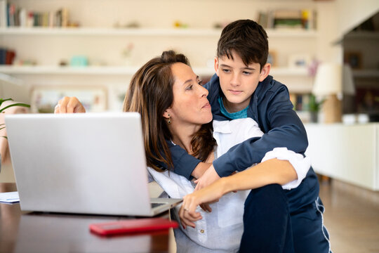 Son embracing working mom during break