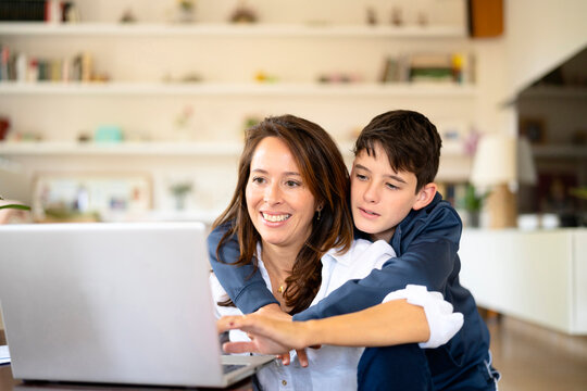 Mother with son browsing data on laptop