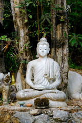 White stone buddha in garden  Wat Pha Lat Monk's Trail at Thailand
