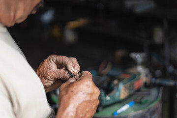 Hands of a man taking a coal to repair it