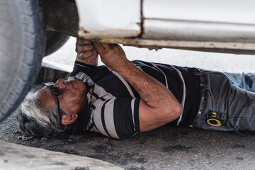 Man mechanic under a car repairing