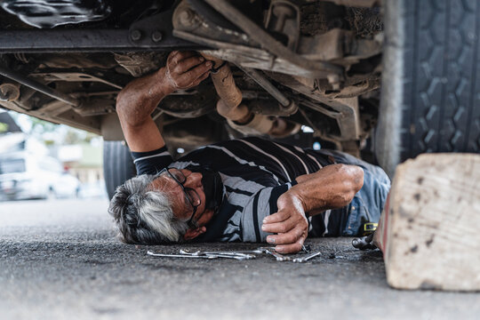 Man mechanic under a car repairing