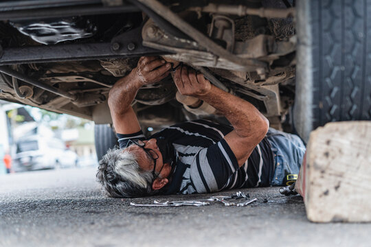 Man mechanic under a car repairing