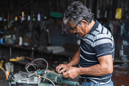 Older Man Repairing A Machine