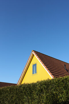 Yellow house behind hedge
