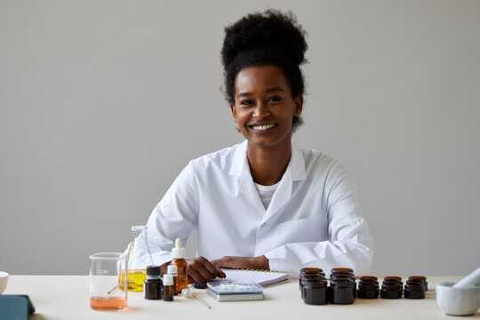 Cheerful black pharmacist with notebook
