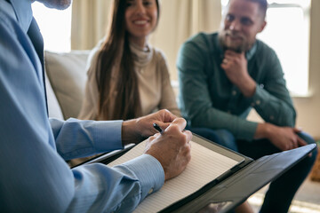 Financial Counselor Writing In Notebook During Session