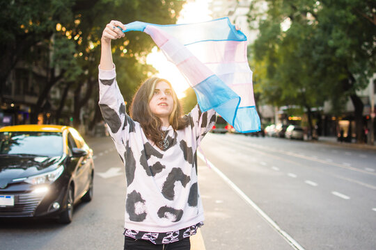 Trans teenage girl with pride flag on a street