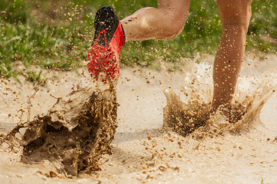 runner splashes on muddy track