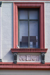 Fototapeta na wymiar Pale Pink Facade around a Baroque Era Window on a White Building.