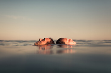Relaxed couple floating together on the sea enjoying the calm