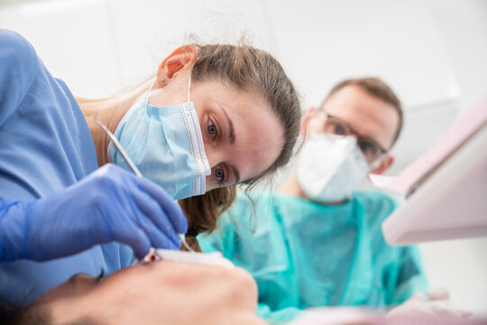 Close Up Of Two Dentists Performing Treatment 