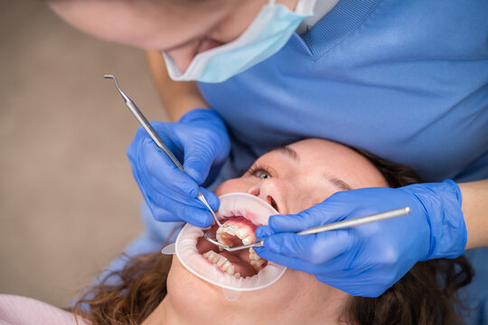 Close Up Of Dentist Adjusting Brackets To Patient