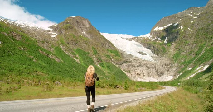 4k video footage of an unrecognisable woman standing and taking photos on her cellphone of mountains in Stryn