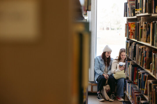 Two friends in library together.
