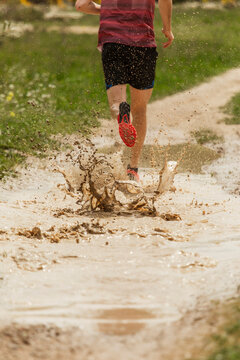 runner splashes on muddy track