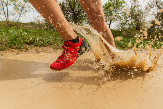 runner splashes on muddy track