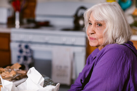Elder content woman relaxing at kitchen