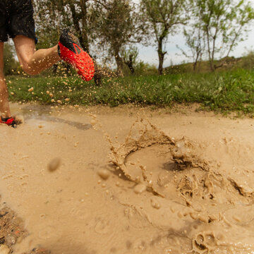runner splashes on muddy track