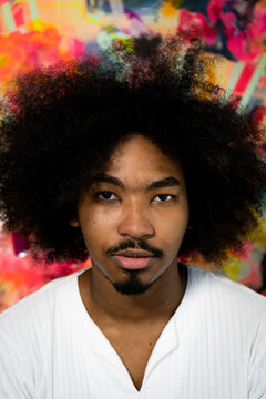 Young Artist Poses In Front Of A Painting On Canvas