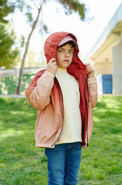 Little boy in a hooded jacket standing outside
