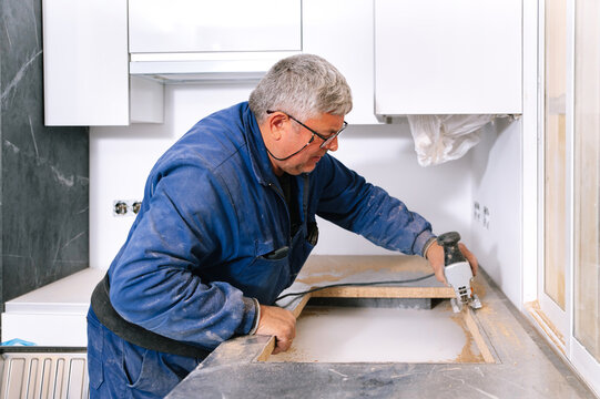Mature handyman cutting countertop with jigsaw