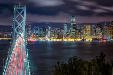 Fototapeta na wymiar Panoramic view of San Francisco skyline and Pier with car trails over Bay Bridge during evening, California, USA
