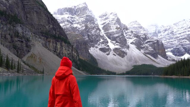 Young woman traveler near the Moraine lake with outstretched hands. Valley of the Ten Peaks. Tourist in Banff National Park, Alberta, Canada.Female holds out her hand. Achievements, Success in nature 