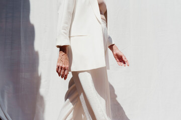 Cropped elegant woman in white suit outdoor