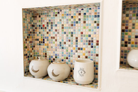 Ceramics sit in a tiled nook