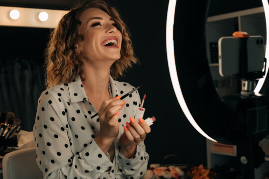 Female beauty blogger laughing while recording a video